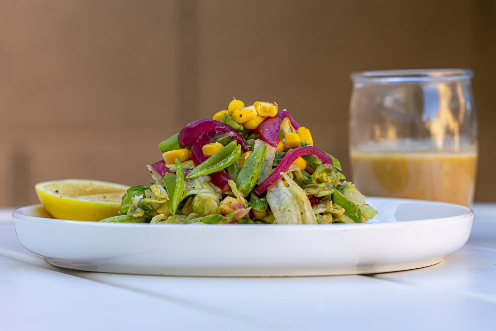Crunch salad with iceberg lettuce, corn, snap peas and pickled red onion